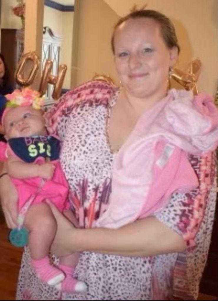 Postpartum Doulas holding baby girl while smiling