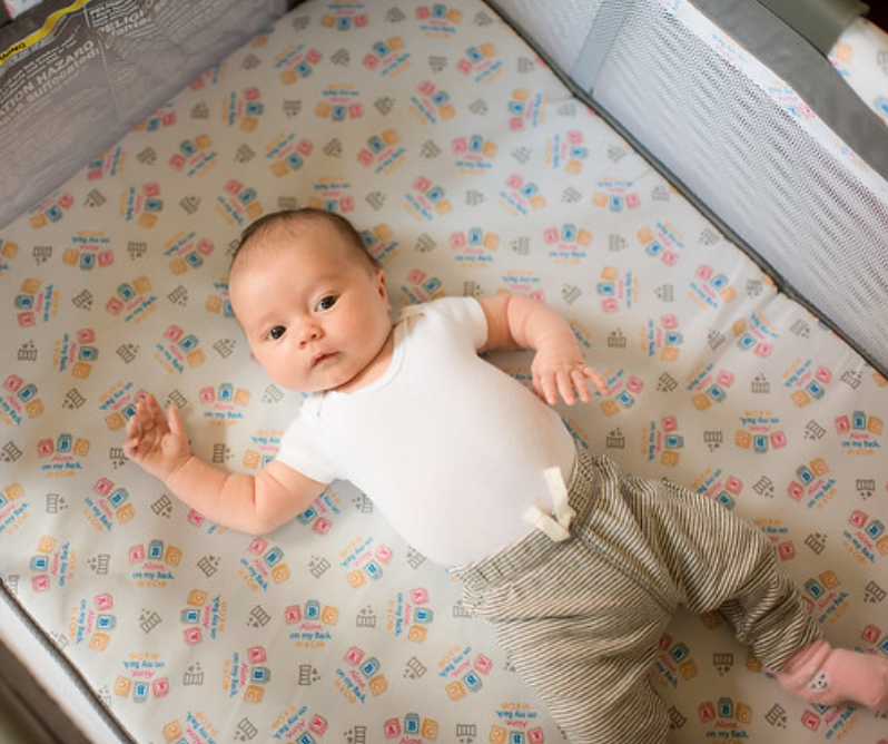 newborn safe sleep demonstrated by infant boy in crib
