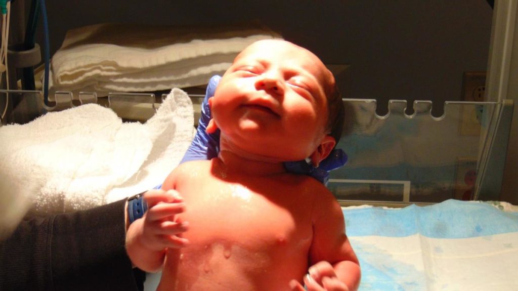 newborn baby getting ready to breastfeed