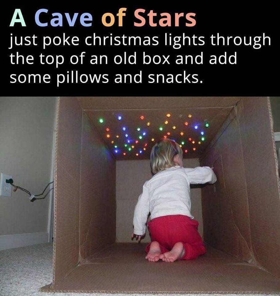 happy infant playing in a cardboard box