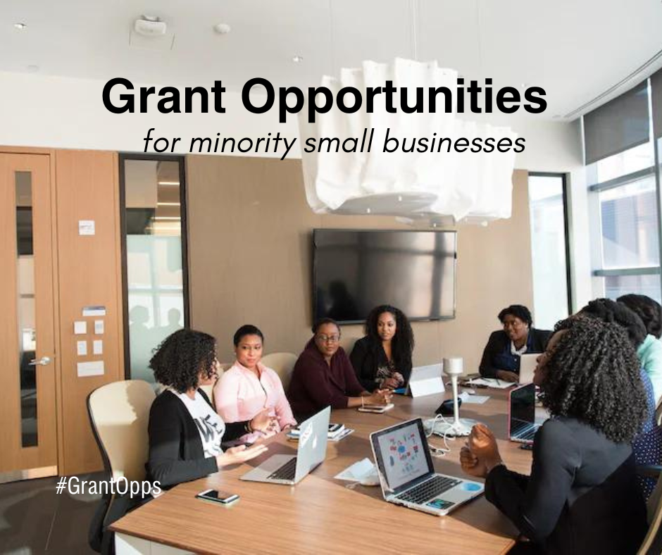8 women of color around conference table in a professional setting. 